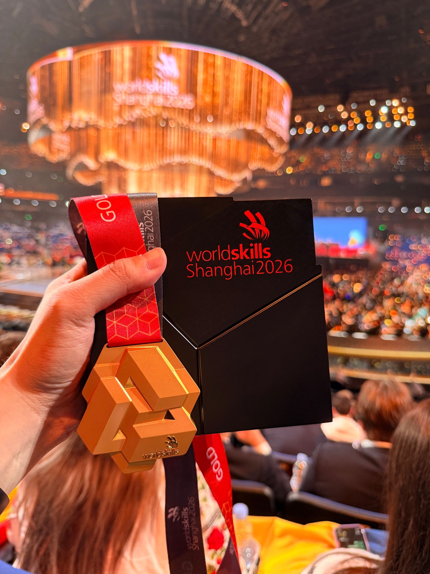 金牌與 WorldSkills Shanghai 2026 的獎牌盒,背景是典禮會場
